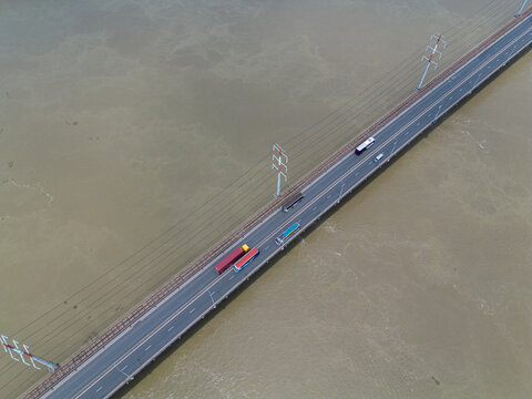 Aerial view of Jamuna Bridge spanning the Jamuna River with vehicles traveling across the road and railway tracks in Tangail District, Dhaka Division, Bangladesh.