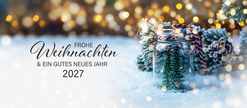 Christmas greeting card with German text Frohe Weihnachten und ein gutes neues Jahr 2027 - Beautiful xmas decoration with Christmas tree in snow - Background banner
