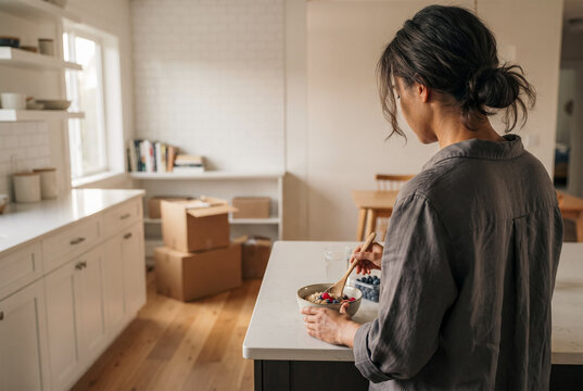 Woman preparing breakfast while settling into a new home
