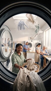 Woman holding basket of clean laundry in community support laundry facility