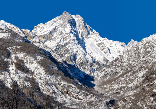 Snow-covered Mont Pelvoux rising above Vallouise Valley in Ecrins National Park on a clear winter day. Hautes-Alpes, French Alps, France