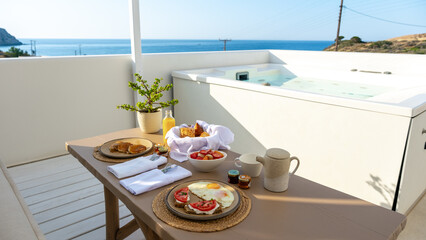 Fototapeta premium Delightful breakfast on a balcony overlooking the serene coast of Milos, Greece