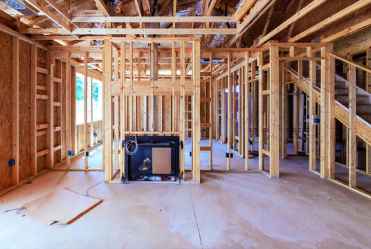 Construction of house with wooden framing open spaces for rooms stairs in residential area