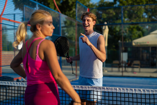 Young people playing padel, having fun outdoors