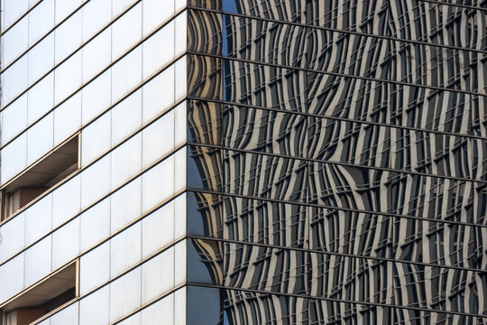 Glass facade of a Jakarta building reflects the surrounding cityscape