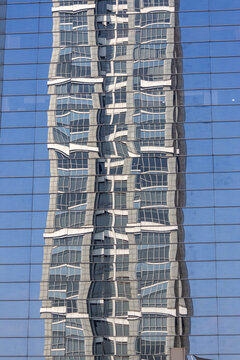 Glass facade of a Jakarta building reflects the surrounding cityscape