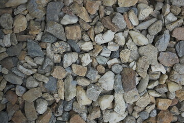 Naklejka premium A charming sidewalk features colorful stones, a winding pathway, and blocks covered in lush green moss, creating a natural, textured scene that blends urban structure with organic beauty.