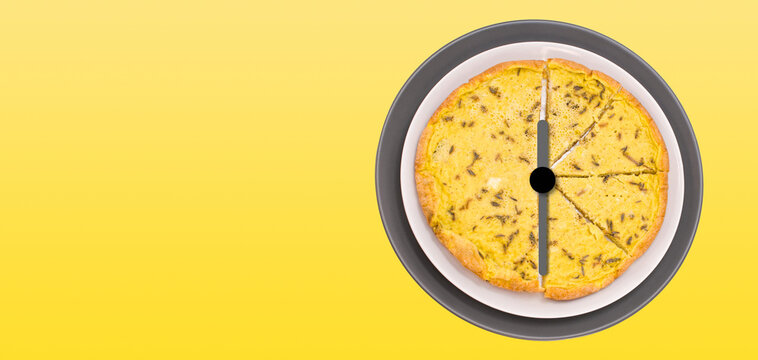 Lancette d'orologio sovrapposte a piatti con frittata, su uno sfondo giallo - ora di pranzo