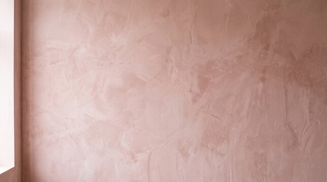 A close up view of a freshly plastered wall surface with a smooth and light brown texture