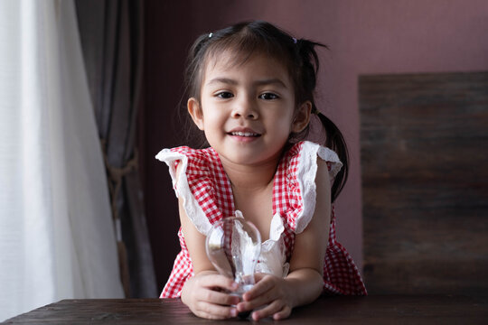 Smiling little girl holding a light bulb, symbolizing creativity, innovation, childhood learning, bright ideas, STEM education, imagination, inspiration, problem solving, and future success.