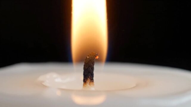Close-up of a Burning Candle Flame in a Dark Environment
