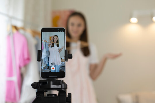 Teenage girl creating a fashion vlog, presenting clothes and outfits on camera, social media content and youth lifestyle