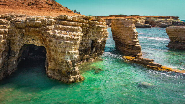 Beautiful natural sea caves and rock arches in clear turquoise water of Cyprus.