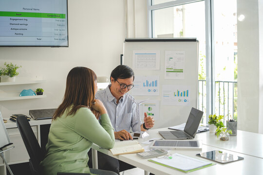 A diverse group of business professionals working together in a modern office, analyzing environmental data and charts to develop eco-friendly, sustainable corporate strategies.