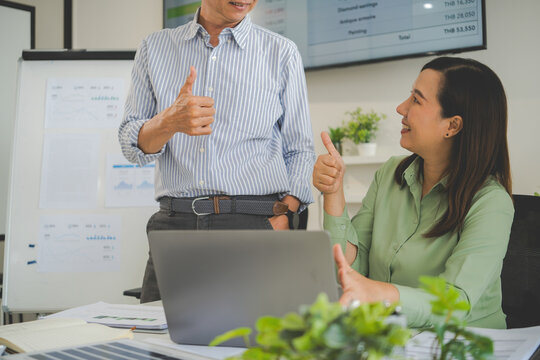 A diverse group of business professionals working together in a modern office, analyzing environmental data and charts to develop eco-friendly, sustainable corporate strategies.