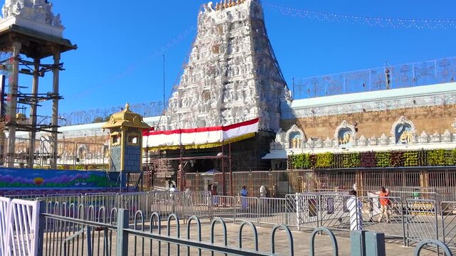 Wide Angle Exterior Of Tirumala Temple Gopuram Featuring Crowd Control Barricades And Painted Mural
