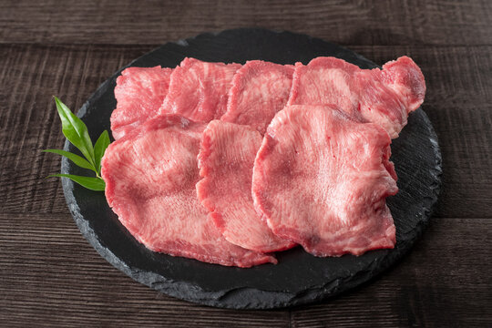 黒い石皿に盛り付けた牛タンの食材写真