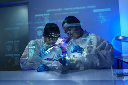 Engineers work in semiconductor or microchip labs in the electronics industry. Electronic engineers in computer technology, 