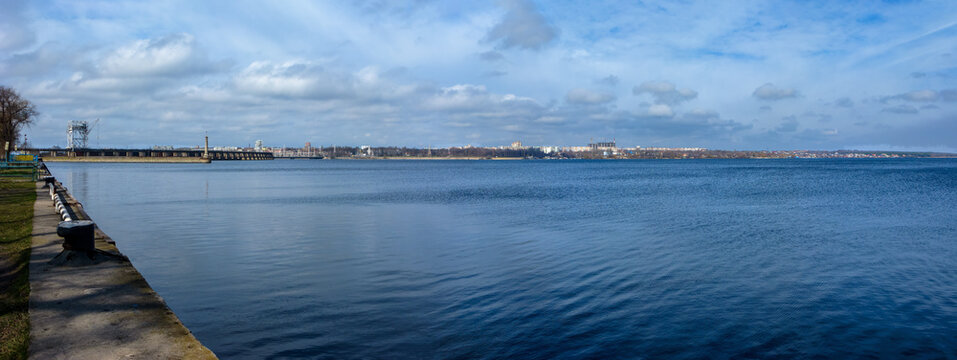 Historic DniproGES dam and residential buildings on a right bank of Dnipro as seen from a river port of Zaporizhzhia, Ukraine
