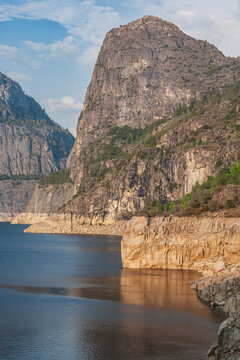 Vertical view of majestic Kolana Rock cliff over Hetch Hetchy Reservoir in Yosemite