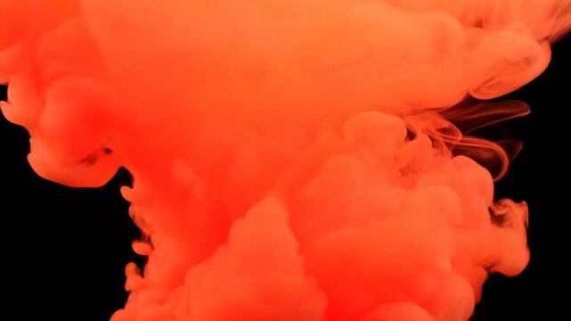 Orange ink cloud abstract formation against black background with soft swirling contours