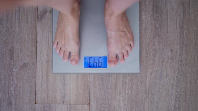 Overweight person stepping on a digital bathroom scale showing a body weight above 100 kg. Weight management, diet, fitness goals, health monitoring and healthy lifestyle concept.