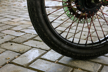 Fototapeta premium Close Up of Bicycle Wheel and Tire on Outdoor Brick Paving, Urban Cycling and Transportation Concept