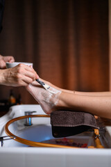Obraz premium Japanese foot spa applying creamy moisturizing mask with brush during relaxing foot care treatment