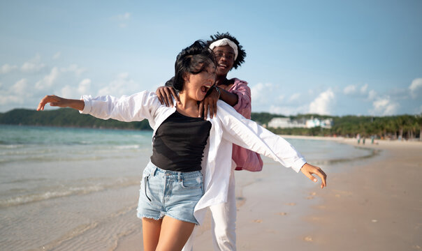 Pure happiness. A young diverse, multiethnic couple enjoys every moment of their tropical getaway