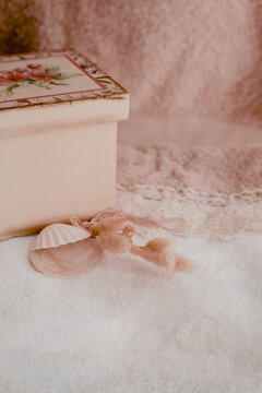 Pink floral box and sea shell bringing calm, peaceful vibes for self-care, wellness, and beauty rituals, creating a serene, feminine pastel aesthetic