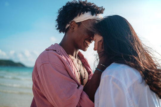 Carefree couple enjoying a tropical beach vacation, laughing making unforgettable memories together