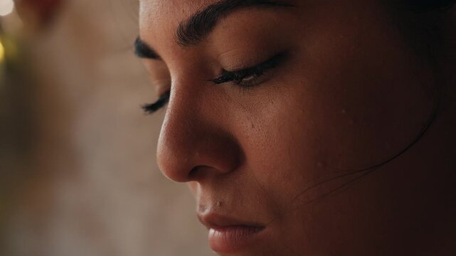 Close up profile of a young peruvian woman chef praying or meditating with eyes closed
