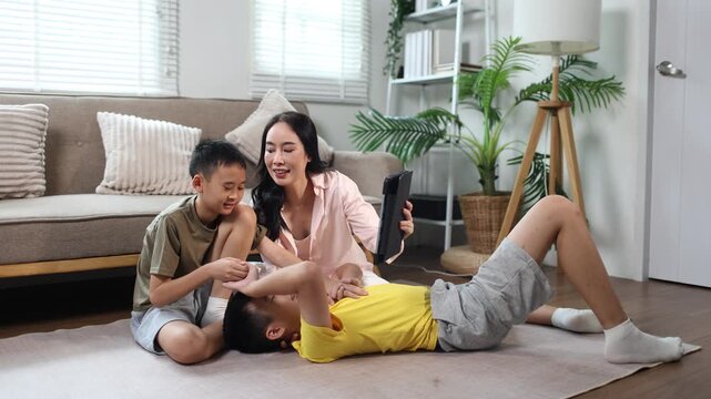 Mother and two children using tablet together at home