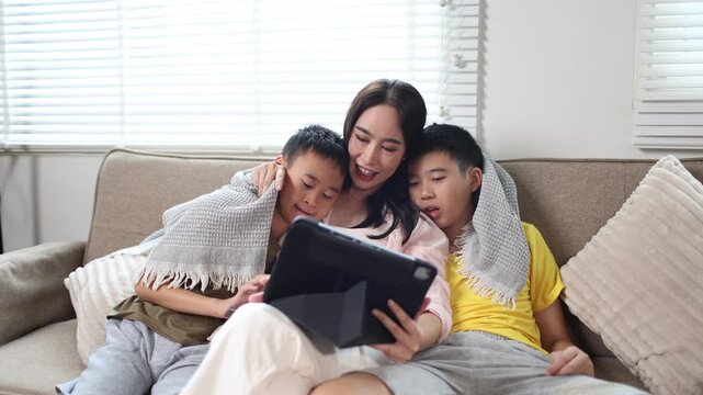 Mother and two children using tablet together at home