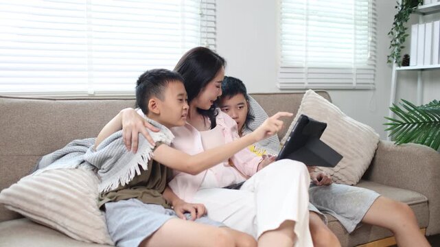 Mother and two children using tablet together at home