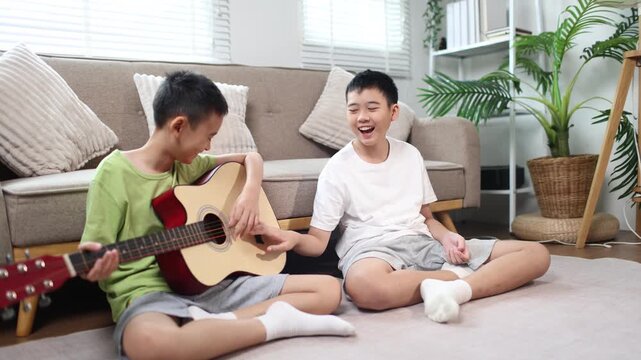 Children playing guitar together at home