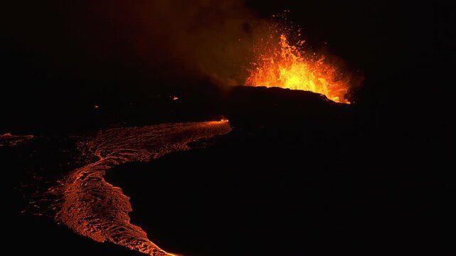 Volcanic eruption in Iceland 2023 at night. Magma flow down a valley.