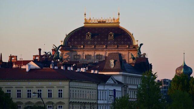 The roof of the National Theatre with its bronze chariot statues and gilded crest at sunrise, Prague, Czech Republic