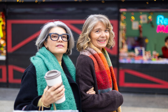Senior women friends enjoying coffee and city shopping