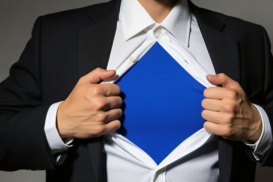 Businessman pulls open white shirt to reveal blue undershirt underneath. Corporate man creates opening for text design logo on blank surface. Professional office worker performs superhero gesture