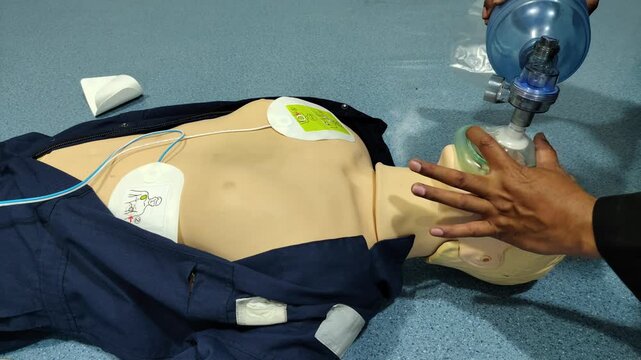 Medical student practicing rescue breathing on a cpr mannequin