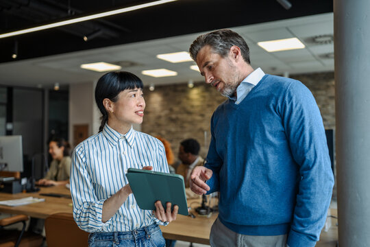 Businesswoman and businessman collaborating on a digital tablet