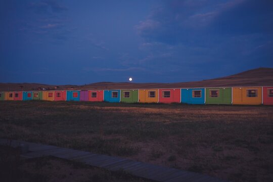 Colorful houses standing in row under full moon at night, Siberia, Russia