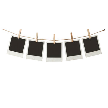 Five blank polaroid photo frames hanging on a string with wooden clothespins