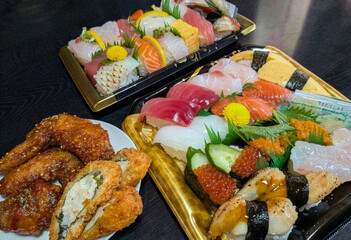 テイクアウトの豪華な寿司盛り合わせと手羽先唐揚げ・フライのパーティーセット © momomi12