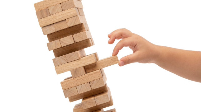 Childs hand carefully removing a wooden block from a precarious tower PNG Isolated on transparent background