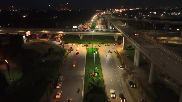 Aerial view of night traffic on a highway with illuminated street lights and an overpass in Gurgaon, Haryana, India.