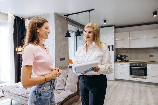 Real estate agent discussing apartment with potential buyer in modern kitchen in apartment