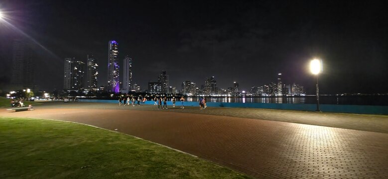 Pedestrians Enjoying Evening Stroll on Cinta Costera Promenade with City Lights