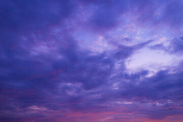 Fototapeta premium Vibrant Sunset Sky with Purple and Orange Clouds,A breathtaking view of a dramatic sunset sky filled with vibrant purple, pink, and orange clouds, creating a peaceful and inspiring natural background.